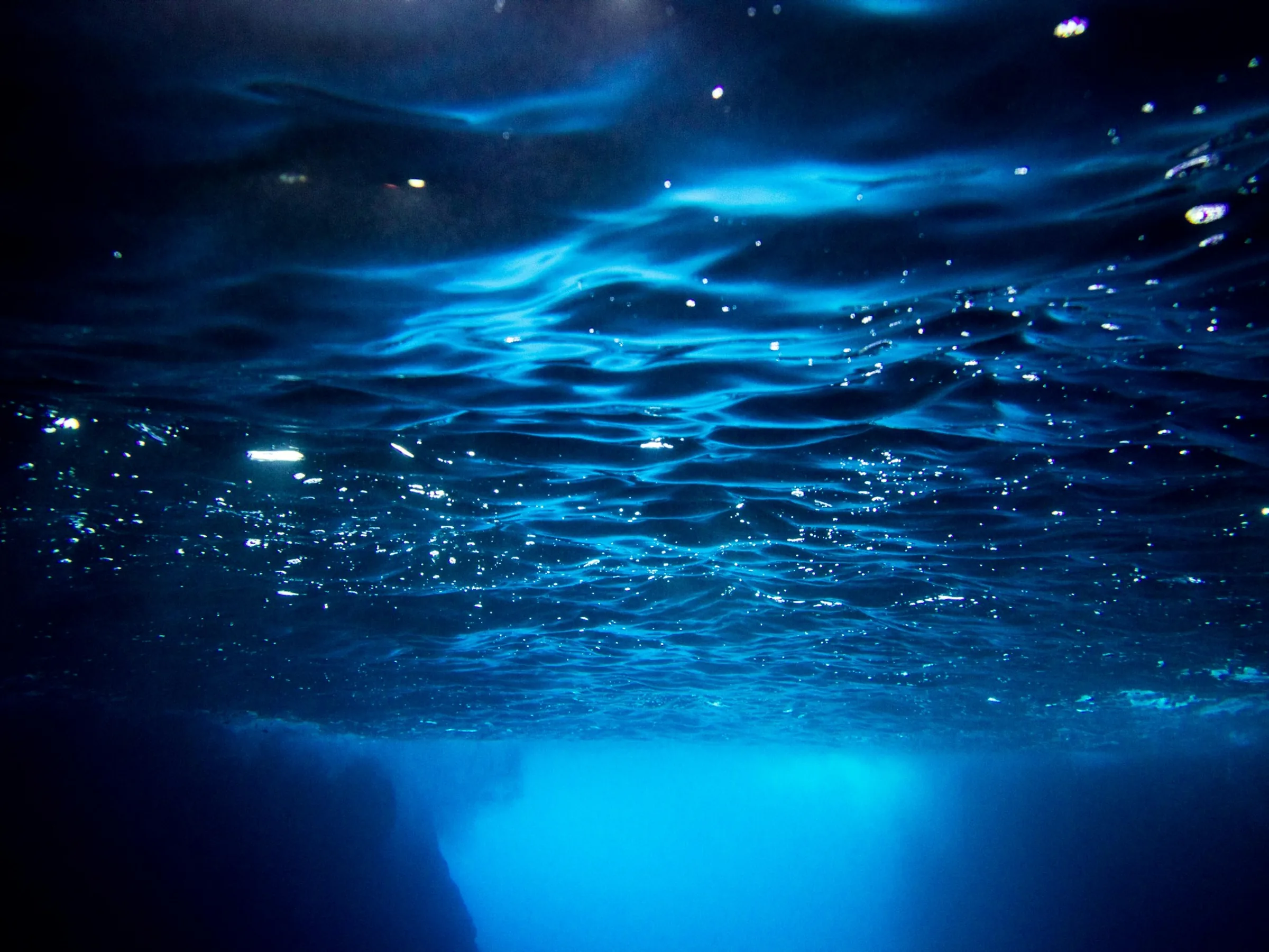 Master scuba diver exploring deep underwater cave